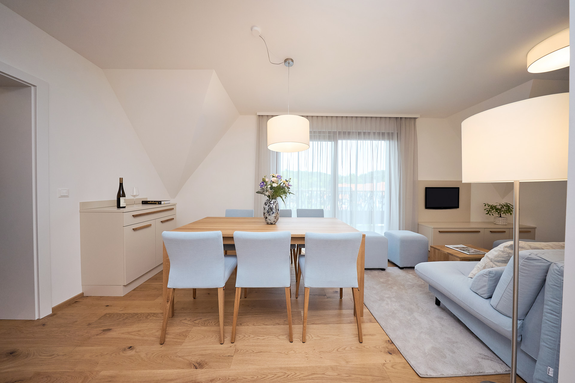 Der Wohnbereich eines Zimmers von zuHaus Gamlitz, blaues Sofa und beige Möbel.